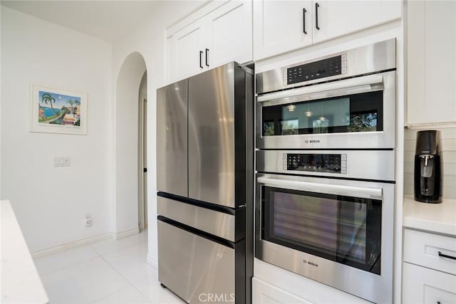 kitchen with light tile patterned flooring, white cabinetry, and appliances with stainless steel finishes