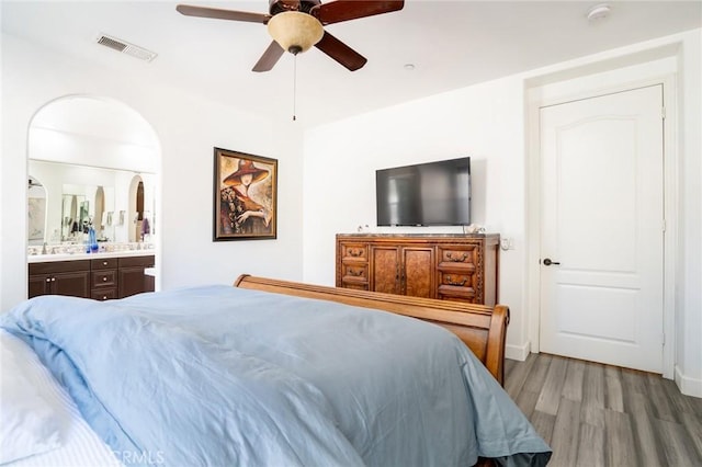 bedroom featuring ceiling fan, light wood-type flooring, and ensuite bath