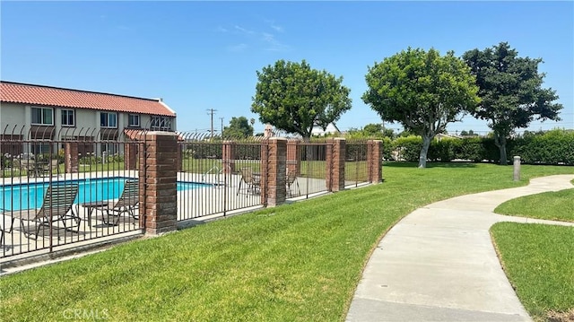 view of swimming pool with a yard