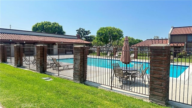 view of swimming pool featuring a lawn and a patio