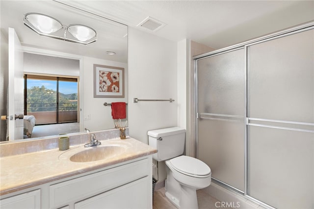 bathroom featuring an enclosed shower, vanity, and toilet