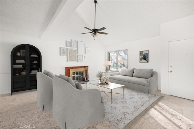 carpeted living room featuring high vaulted ceiling, ceiling fan, a textured ceiling, a fireplace, and beam ceiling