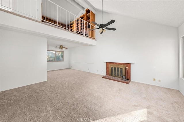 unfurnished living room featuring carpet, ceiling fan, a fireplace, and high vaulted ceiling