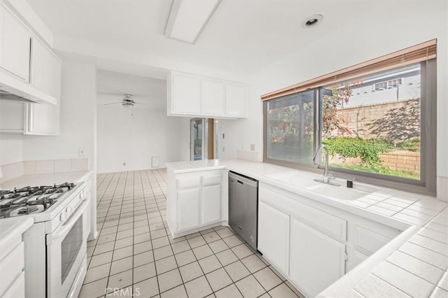 kitchen with kitchen peninsula, white gas range oven, ceiling fan, dishwasher, and white cabinets