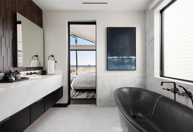 bathroom with a tub to relax in and vanity