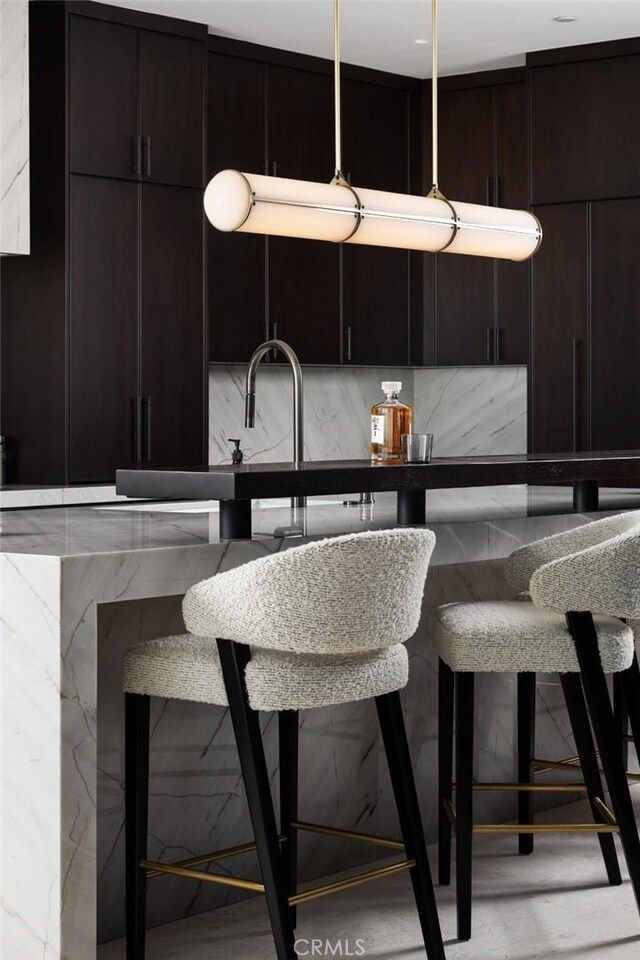 kitchen with a kitchen breakfast bar and backsplash