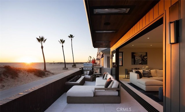 patio terrace at dusk featuring an outdoor living space and a grill