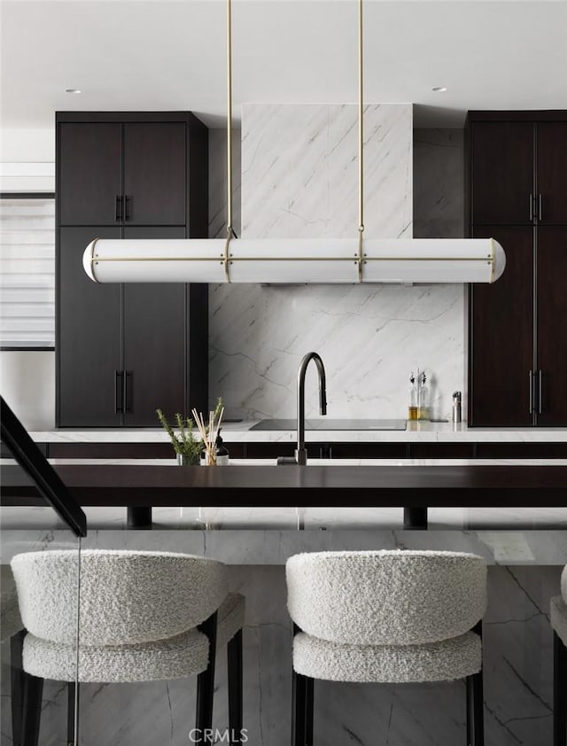 kitchen featuring a breakfast bar, backsplash, and dark brown cabinets