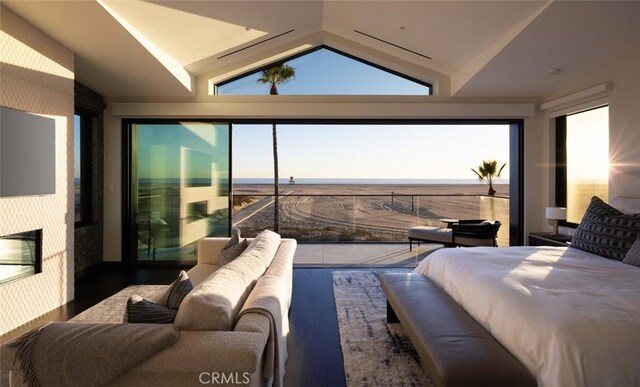 bedroom featuring lofted ceiling, a fireplace, and hardwood / wood-style flooring