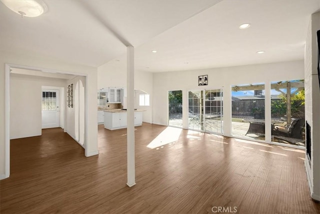 unfurnished living room with dark hardwood / wood-style flooring and a healthy amount of sunlight