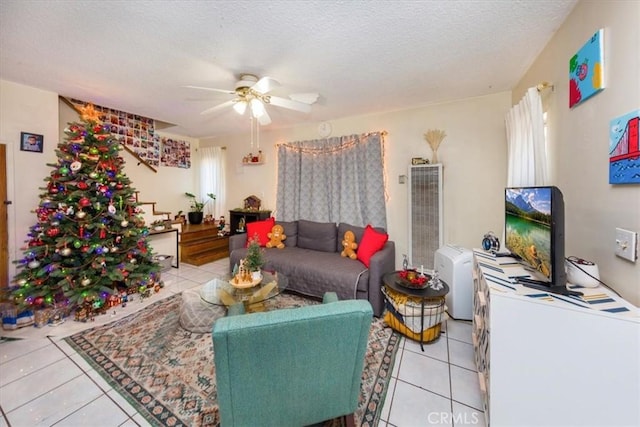 living room featuring ceiling fan, a textured ceiling, and light tile patterned flooring