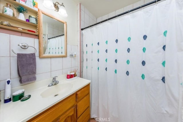 bathroom with a shower with shower curtain, tile walls, backsplash, and vanity