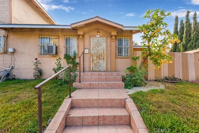 view of exterior entry with a yard