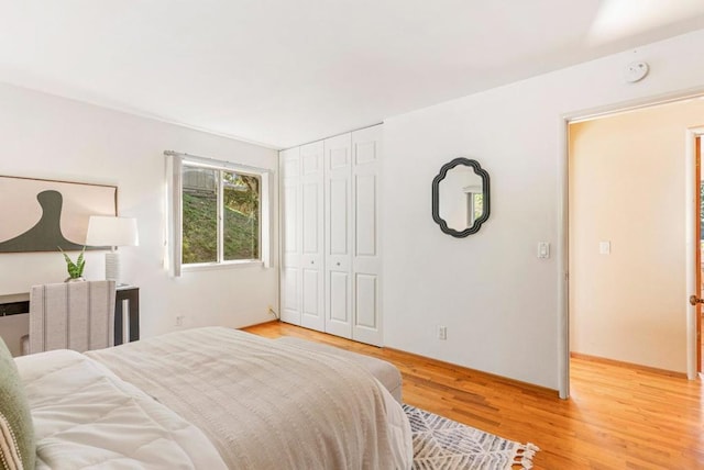 bedroom with a closet, radiator, and light hardwood / wood-style flooring