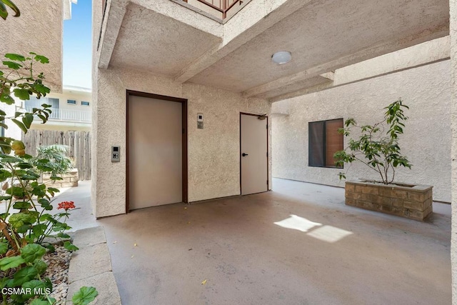 entrance to property featuring a patio area and elevator