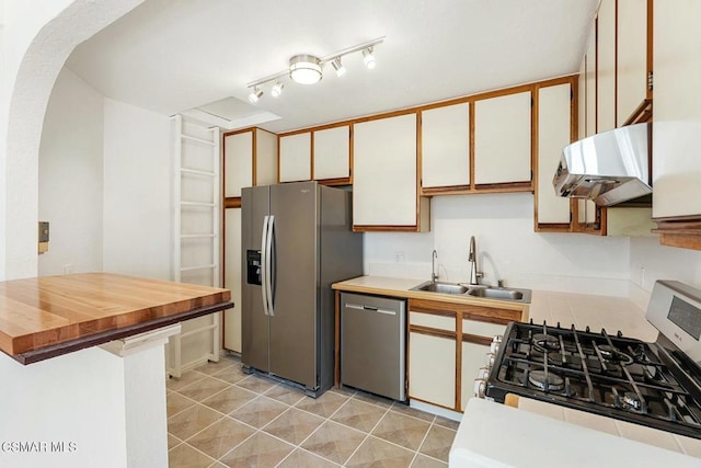 kitchen featuring sink, white cabinetry, light tile patterned floors, and stainless steel appliances