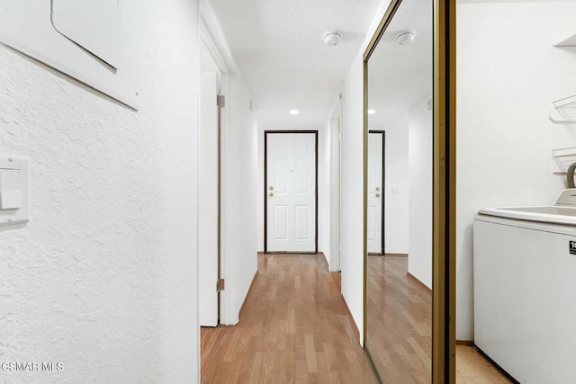 hallway featuring washer / dryer and light hardwood / wood-style flooring