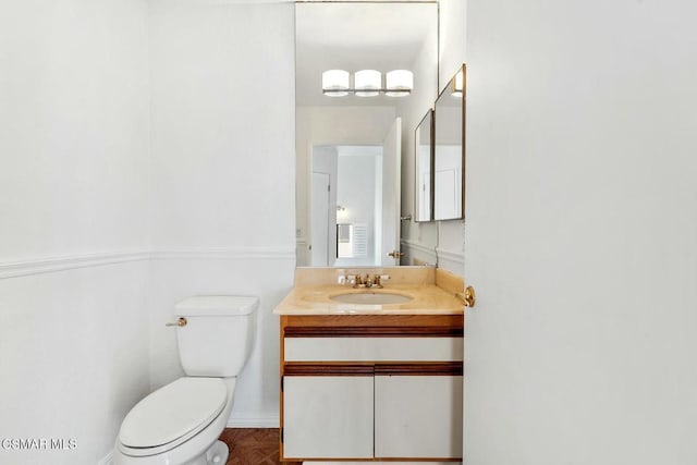 bathroom with toilet, parquet floors, and vanity