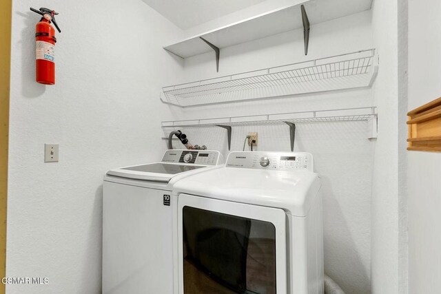 clothes washing area with washer and clothes dryer