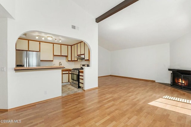 unfurnished living room featuring high vaulted ceiling, light hardwood / wood-style floors, and beamed ceiling