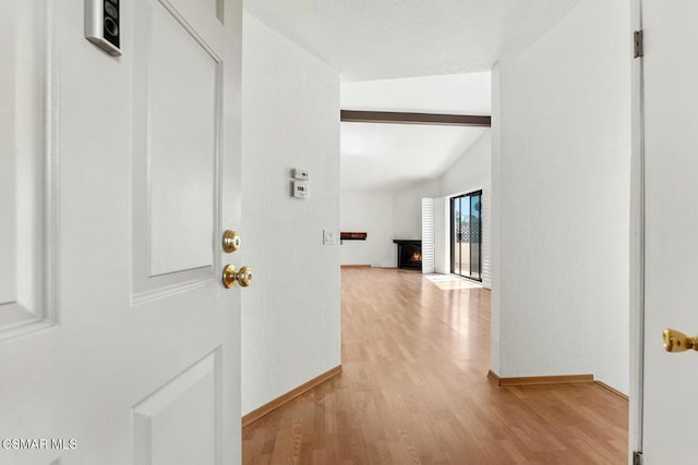 corridor featuring vaulted ceiling with beams and light hardwood / wood-style floors