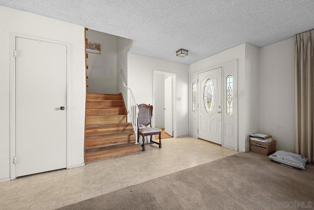 entryway with light carpet and a textured ceiling