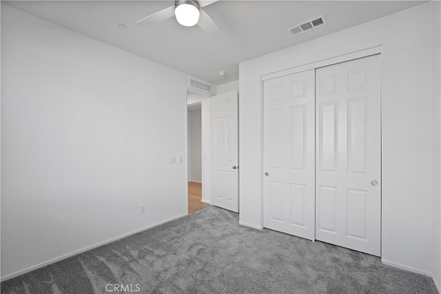 unfurnished bedroom featuring ceiling fan, a closet, and carpet flooring