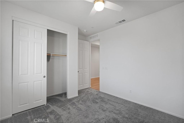 unfurnished bedroom featuring ceiling fan, a closet, and dark carpet