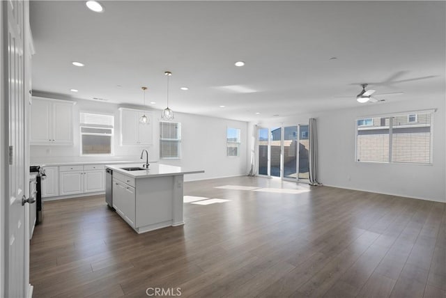 kitchen with white cabinetry, ceiling fan, decorative light fixtures, a kitchen island with sink, and sink