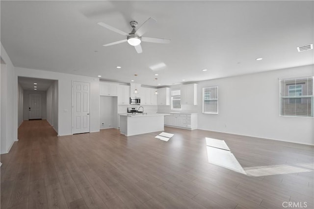 unfurnished living room with ceiling fan, plenty of natural light, and light hardwood / wood-style floors