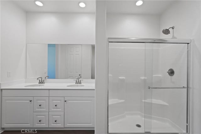 bathroom featuring walk in shower and vanity