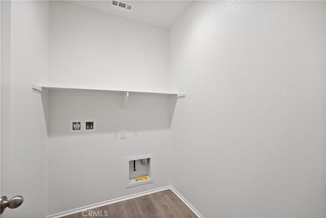 washroom with wood-type flooring and hookup for a washing machine