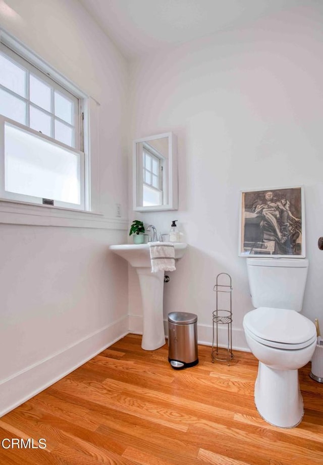 bathroom with toilet and hardwood / wood-style flooring