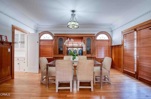 dining space featuring wooden walls and light hardwood / wood-style flooring