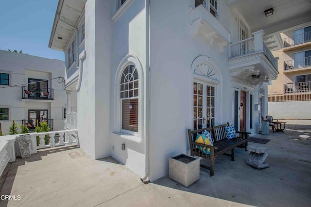 view of exterior entry with french doors and a balcony