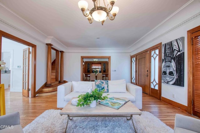 living room featuring crown molding, light wood-type flooring, and an inviting chandelier