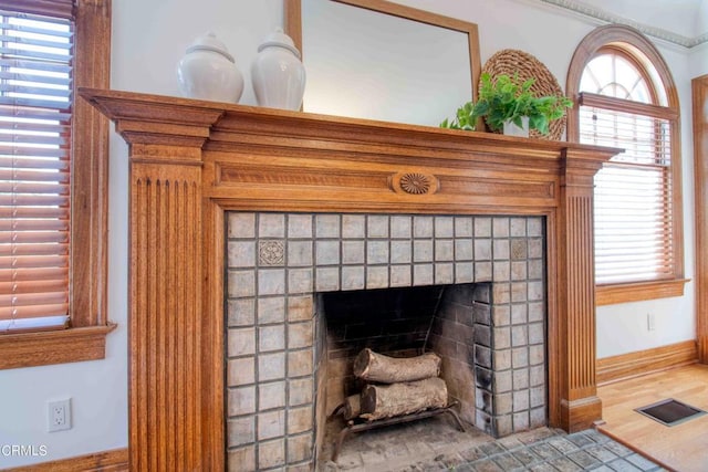 details featuring wood-type flooring and a tiled fireplace