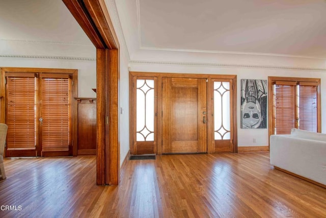 foyer with light hardwood / wood-style flooring and crown molding