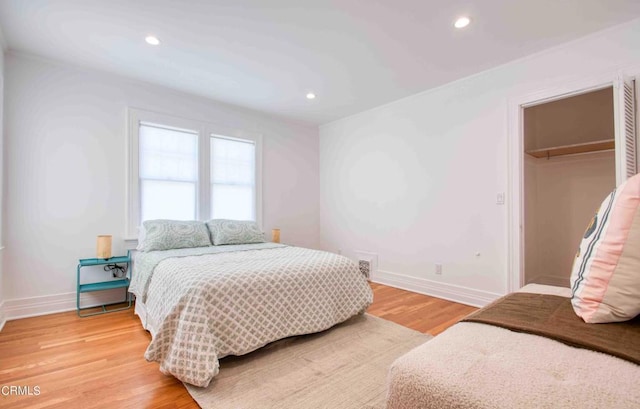 bedroom featuring a spacious closet, a closet, and hardwood / wood-style floors