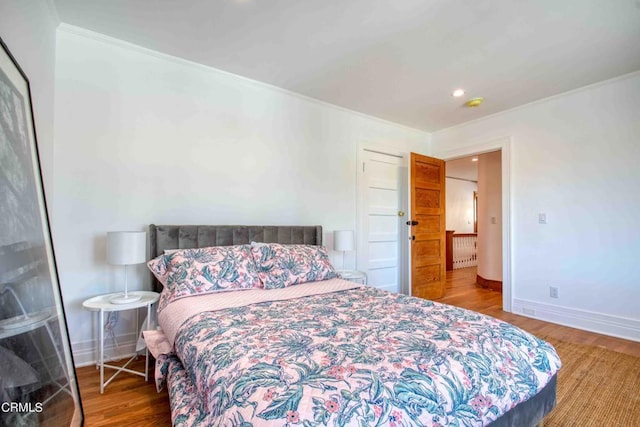 bedroom with ornamental molding and hardwood / wood-style flooring