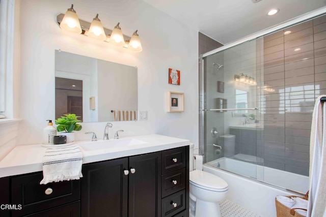 full bathroom featuring toilet, vanity, and shower / bath combination with glass door