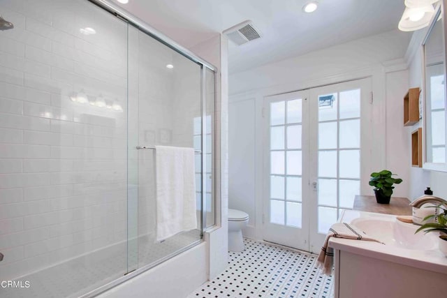 full bathroom with toilet, vanity, a healthy amount of sunlight, french doors, and shower / bath combination with glass door