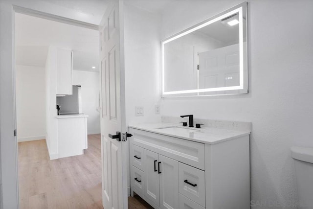 bathroom featuring hardwood / wood-style flooring, vanity, and toilet