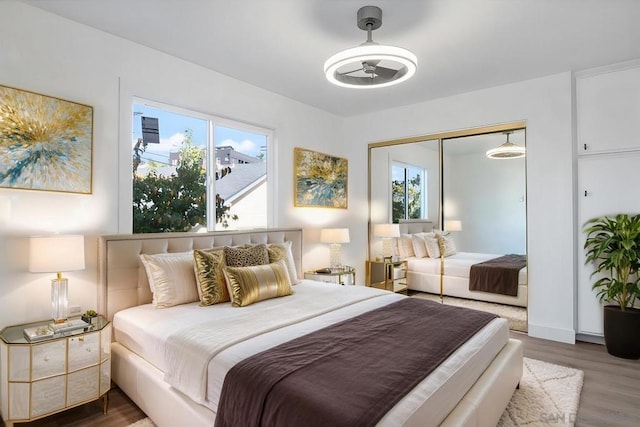 bedroom with dark wood-type flooring, ceiling fan, and a closet