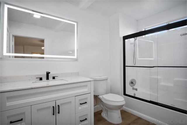 full bathroom featuring toilet, vanity, bath / shower combo with glass door, and hardwood / wood-style floors