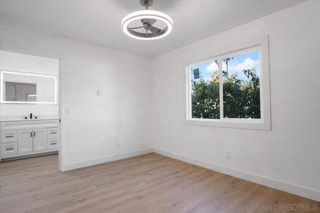 spare room featuring sink and light wood-type flooring