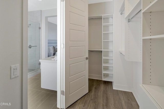 walk in closet with dark hardwood / wood-style flooring