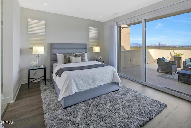 bedroom with access to outside, baseboards, and wood finished floors