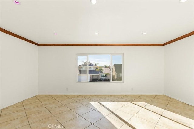 spare room with light tile patterned floors and crown molding