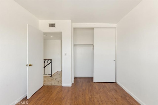 unfurnished bedroom with wood-type flooring and a closet